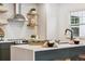 Bright kitchen featuring decorative floating shelves, stainless steel range hood and gas range at 4465 N Umatilla St, Denver, CO 80211