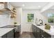 Beautiful kitchen with stylish backsplash, stainless steel appliances, and dark green cabinetry at 4465 N Umatilla St, Denver, CO 80211