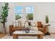 Cozy living room featuring a comfortable leather sofa, stylish decor, and an abundance of natural light at 4465 N Umatilla St, Denver, CO 80211
