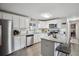 Well-lit kitchen featuring stainless steel appliances, white cabinetry, and an island with bar stools at 1320 Quari St, Aurora, CO 80011