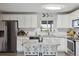 Bright and modern kitchen features stainless steel appliances, white cabinetry, and a stylish center island at 1320 Quari St, Aurora, CO 80011