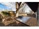 Backyard with wooden deck featuring chairs, a patterned outdoor rug, and mature trees at 2435 S Meade St, Denver, CO 80219