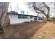 Spacious backyard with wooden deck, air conditioning unit, a white house exterior, and mature trees at 2435 S Meade St, Denver, CO 80219