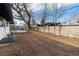 Backyard with wooden deck and an air conditioning unit near a white house exterior with a wooden fence at 2435 S Meade St, Denver, CO 80219