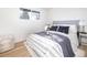Bedroom featuring a bed with stylish patterned bedding, a large window, and light wood flooring at 2435 S Meade St, Denver, CO 80219