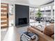 Bright living room featuring a black brick fireplace, hardwood floors, and many windows at 2435 S Meade St, Denver, CO 80219