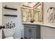 Stylish powder room featuring rustic wood-framed mirrors and shelves for added storage at 10743 W Berry Pl, Littleton, CO 80127