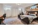 Cozy bedroom featuring a rustic wood accent wall, a bed, and lots of natural light at 10743 W Berry Pl, Littleton, CO 80127