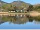 Tranquil lake view with a backdrop of lush trees, park amenities, and majestic mountain, reflecting serenity and natural beauty at 10743 W Berry Pl, Littleton, CO 80127