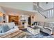 Open living space with white railings, wood floors, fireplace and a view to the kitchen at 10743 W Berry Pl, Littleton, CO 80127
