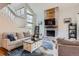 Open-concept living room featuring a brick fireplace, lots of natural light, and wood floors at 10743 W Berry Pl, Littleton, CO 80127