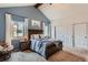 Comfortable main bedroom featuring vaulted ceilings, a wooden bed frame, and dual closets at 10743 W Berry Pl, Littleton, CO 80127