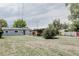 Large backyard with a covered patio and spacious lawn, ideal for outdoor activities at 1200 S Patton Ct, Denver, CO 80219