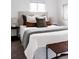 Bright bedroom featuring an upholstered headboard and bench with decorative pillows at 1200 S Patton Ct, Denver, CO 80219