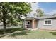 Well-maintained single-story home featuring a charming front porch and complemented by a lush, green lawn at 1200 S Patton Ct, Denver, CO 80219