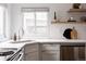 Updated kitchen features stainless steel dishwasher and sink with stylish subway tile at 1200 S Patton Ct, Denver, CO 80219
