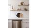 Close-up of kitchen features stainless steel dishwasher, floating shelves and subway tile backsplash at 1200 S Patton Ct, Denver, CO 80219
