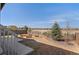 Fenced backyard featuring several raised garden beds, mature trees and neighborhood views beyond at 455 N Old Hammer St, Aurora, CO 80018