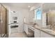Bright bathroom featuring double vanities, granite countertops, and a glass-enclosed shower at 455 N Old Hammer St, Aurora, CO 80018