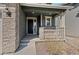 A welcoming front porch with stone accents and a dark-colored front door at 455 N Old Hammer St, Aurora, CO 80018