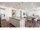 Open-concept kitchen featuring a large island with seating, hardwood floors, and seamlessly connected to the dining and living areas at 455 N Old Hammer St, Aurora, CO 80018