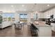 Bright, open-concept kitchen featuring white cabinetry, granite countertops, stainless steel appliances, and a spacious island with bar seating at 455 N Old Hammer St, Aurora, CO 80018