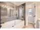 Updated bathroom with a glass enclosed tub, tiled walls, and a window with a view of the outdoors at 19383 E Chaffee Pl, Denver, CO 80249