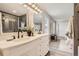 A bathroom with a large double sink and vanity with views of a window and doorway at 19383 E Chaffee Pl, Denver, CO 80249