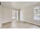 Empty bedroom with multiple windows providing a view of the outdoors, light colored walls and wood floors at 19383 E Chaffee Pl, Denver, CO 80249