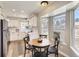 Eat-in kitchen with white cabinets, stainless appliances, and large windows at 19383 E Chaffee Pl, Denver, CO 80249