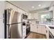 Modern kitchen featuring stainless steel appliances, white cabinetry, and subway tile backsplash at 19383 E Chaffee Pl, Denver, CO 80249