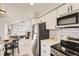 Modern kitchen with stainless steel appliances, white cabinets, and open view to living area at 19383 E Chaffee Pl, Denver, CO 80249