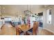 Elegant dining room with hardwood floors, modern chandelier, and an open-concept view of the kitchen and outdoor patio at 220 High Meadows Loop, Elizabeth, CO 80107