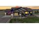 Inviting single-Gathering home at dusk with warm interior lights, complemented by an American flag at 220 High Meadows Loop, Elizabeth, CO 80107