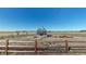 Exterior view of a modern greenhouse surrounded by raised garden beds and a rustic fence at 220 High Meadows Loop, Elizabeth, CO 80107