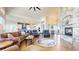 Open-concept living room flows into the kitchen, with hardwood floors, stone fireplace, and bright lighting at 220 High Meadows Loop, Elizabeth, CO 80107
