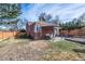 Quaint red brick home featuring a cozy patio and landscaped backyard with privacy fence at 3083 Ash St, Denver, CO 80207