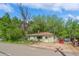 Quaint single-story home surrounded by mature trees and a driveway at 3384 Avenue F, Kittredge, CO 80457