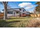 Backyard view of the house with a wooden fence, deck, and mature trees at 15974 E Loyola Dr, Aurora, CO 80013