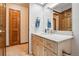 Bathroom featuring a wooden vanity with granite countertop, complemented by wooden doors and neutral decor at 15974 E Loyola Dr, Aurora, CO 80013