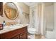 Bathroom featuring marble countertop vanity, large mirror, and a shower-tub combination with patterned shower curtain at 15974 E Loyola Dr, Aurora, CO 80013