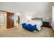 Bright bedroom featuring a bed, bench, and a door leading to a walk-in closet for ample storage at 15974 E Loyola Dr, Aurora, CO 80013