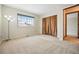 Inviting bedroom with a large window, soft carpet, and a glimpse into the hallway, offering a cozy and functional space at 15974 E Loyola Dr, Aurora, CO 80013