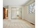 Bright bedroom with mirrored closet doors, neutral carpet, and a window offering natural light and space at 15974 E Loyola Dr, Aurora, CO 80013