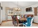 Elegant dining room with a vaulted ceiling, a chandelier, a wooden table with seating for ten, and a large window at 15974 E Loyola Dr, Aurora, CO 80013