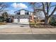 Charming two-story home featuring a three-car garage, blue trim, brick accents, and mature trees in a well-maintained neighborhood at 15974 E Loyola Dr, Aurora, CO 80013