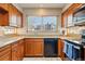 Traditional kitchen featuring wood cabinets, granite countertops, and a window overlooking the neighborhood at 15974 E Loyola Dr, Aurora, CO 80013