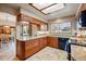 Well-lit kitchen featuring granite countertops, wooden cabinets, tile flooring, modern appliances, and a view to the backyard at 15974 E Loyola Dr, Aurora, CO 80013