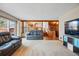 Spacious living room featuring a wood beam and bar area at 15974 E Loyola Dr, Aurora, CO 80013