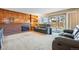 Carpeted living room with a brick fireplace, wood wall, and sliding glass door at 15974 E Loyola Dr, Aurora, CO 80013